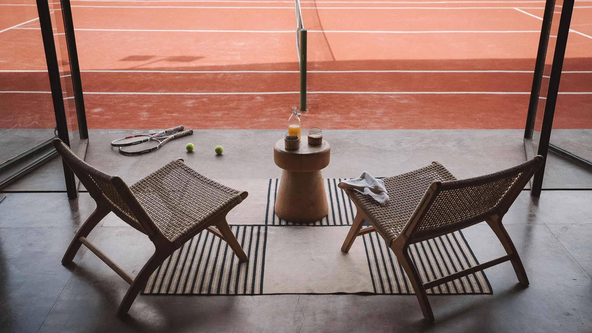 Lounge chairs at the edge of the clay court